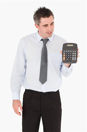 Accountant looking at a calculator against a white background Stock Photo - Budget Royalty-Free & Subscription, Code: 400-04918080