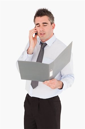 simsearch:400-06393704,k - Portrait of a businessman making a phone call while holding a binder against a white background Stock Photo - Budget Royalty-Free & Subscription, Code: 400-04918090