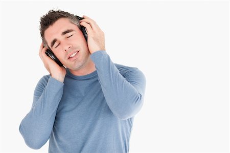 simsearch:400-05717354,k - Handsome man listening to music against a white background Stock Photo - Budget Royalty-Free & Subscription, Code: 400-04918291