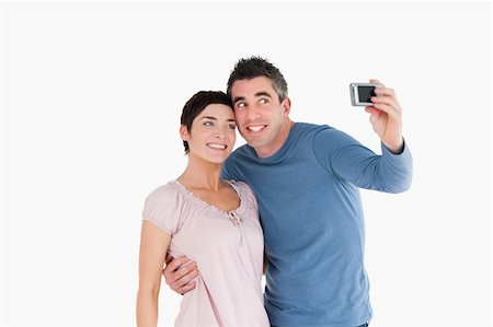 simsearch:400-04151970,k - Couple taking a picture of themselves against a white background Fotografie stock - Microstock e Abbonamento, Codice: 400-04918338