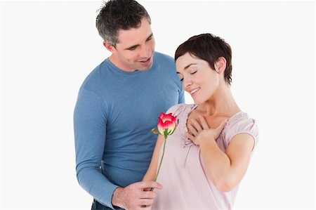 simsearch:400-05294518,k - Husband offering a rose to his smiling wife against a white background Fotografie stock - Microstock e Abbonamento, Codice: 400-04918371