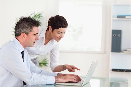 simsearch:400-04918393,k - Woman pointing at something to her colleague on a laptop in an office Stock Photo - Budget Royalty-Free & Subscription, Code: 400-04918386