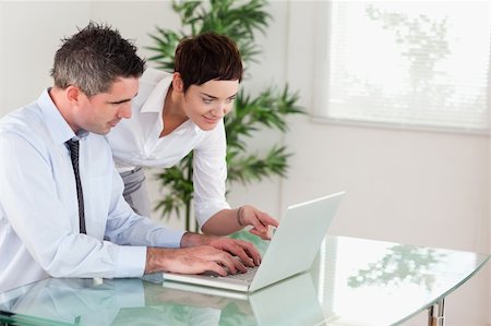 simsearch:400-04918393,k - Businesswoman pointing at something to her colleague on a laptop in an office Stock Photo - Budget Royalty-Free & Subscription, Code: 400-04918388