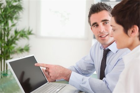 simsearch:400-04918393,k - Manager pointing at something to his secretary on a laptop in an office Stock Photo - Budget Royalty-Free & Subscription, Code: 400-04918398