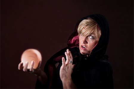 simsearch:400-05347613,k - Caucasian female fortuneteller wearing black viel holds crystal ball over maroon background Stock Photo - Budget Royalty-Free & Subscription, Code: 400-04910574