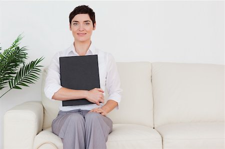 Brunette short-haired woman sitting on a sofa in a waiting room Stock Photo - Budget Royalty-Free & Subscription, Code: 400-04910838