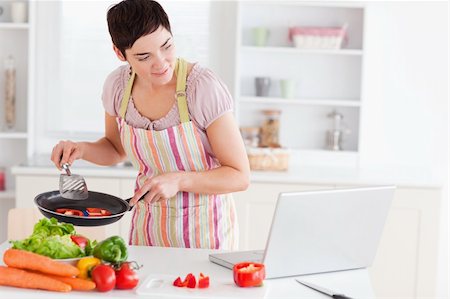 red pepper - Beautiful woman cooking with receipt on laptop in the kitchen Foto de stock - Super Valor sin royalties y Suscripción, Código: 400-04910845