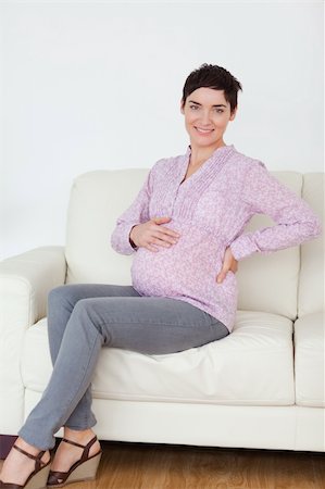 Smiling pregnant woman sitting on a sofa in a waiting room Stock Photo - Budget Royalty-Free & Subscription, Code: 400-04910869