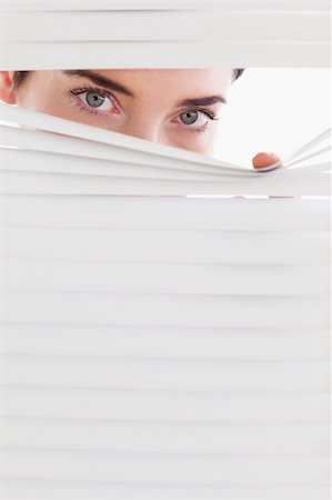 peeping through - Businesswoman peeking through a venetian blind in an office Stock Photo - Budget Royalty-Free & Subscription, Code: 400-04910928