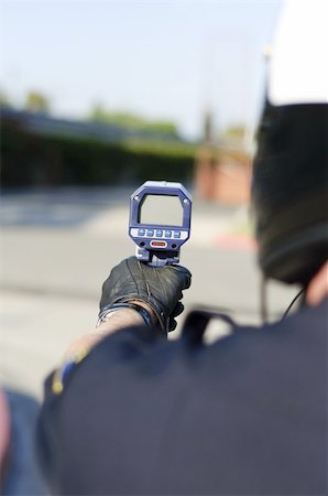 a motorcycle police officer pointing his radar gun at traffic. Fotografie stock - Microstock e Abbonamento, Codice: 400-04913169