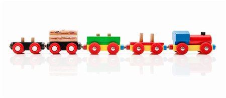 Wooden toy train with a locomotive and four carriages, half unloaded from left to right with a subtle reflection on a white background Photographie de stock - Aubaine LD & Abonnement, Code: 400-04913187