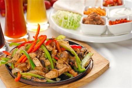original fajita sizzling smoking hot served on iron plate ,with selection of beer and fresh vegetables on background ,MORE DELICIOUS FOOD ON PORTFOLIO Stock Photo - Budget Royalty-Free & Subscription, Code: 400-04913972