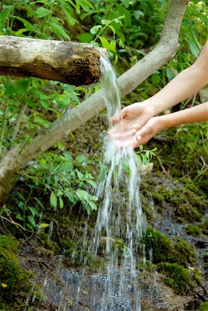 washing hands by spring water under wooden gutter over green natural background Photographie de stock - Aubaine LD & Abonnement, Code: 400-04925207