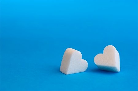 Lump of sugar shaped heart with blue background. Foto de stock - Super Valor sin royalties y Suscripción, Código: 400-04925346