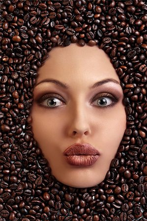 close up of a girl's face drowned in coffee beans blowing a kiss Foto de stock - Super Valor sin royalties y Suscripción, Código: 400-04925558