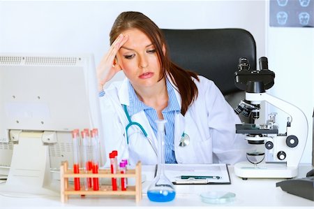 simsearch:400-04925813,k - Concerned medical doctor woman sitting at office table and holding hand near head Stock Photo - Budget Royalty-Free & Subscription, Code: 400-04925797