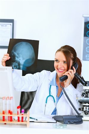 simsearch:400-04925813,k - Smiling medical doctor woman talking on phone and holding patients roentgen Stock Photo - Budget Royalty-Free & Subscription, Code: 400-04925809