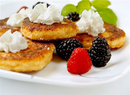 Cottage cheese pancakes garnished with fresh berries Foto de stock - Super Valor sin royalties y Suscripción, Código: 400-04925838