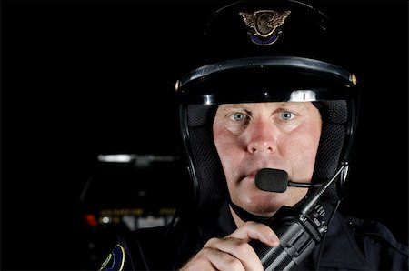 first responder - a police officer in the night about to talk on his hand held radio. Stock Photo - Budget Royalty-Free & Subscription, Code: 400-04926345