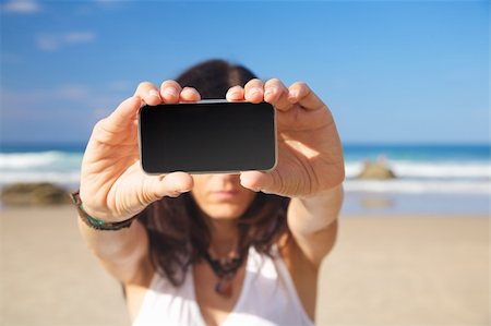 quintanilla (artist) - smart phone in woman hand on a beach in Asturias Spain Photographie de stock - Aubaine LD & Abonnement, Code: 400-04921598