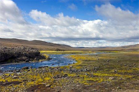 The rocky tundra meadow surrounding the river stream amidst the volcanic lava fields and rhyolite mountains in the Landmannalaugar region in Iceland Stock Photo - Budget Royalty-Free & Subscription, Code: 400-04923201