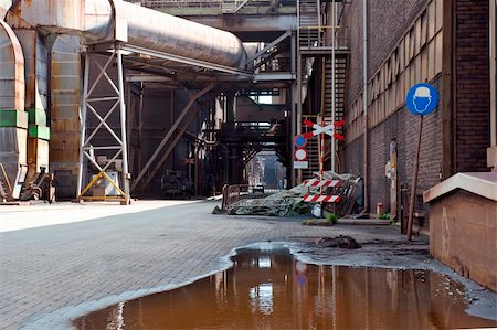 passagem de nível - An gloomy, dim alley at a heavy industrial plant Foto de stock - Royalty-Free Super Valor e Assinatura, Número: 400-04923802