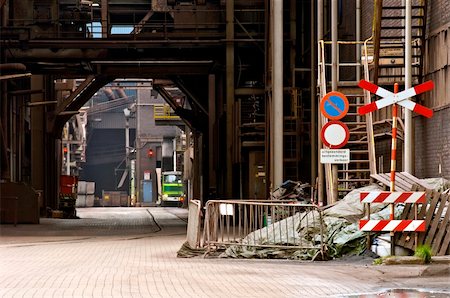 passagem de nível - A dimly lit alley at a heavy industry plant Foto de stock - Royalty-Free Super Valor e Assinatura, Número: 400-04923822