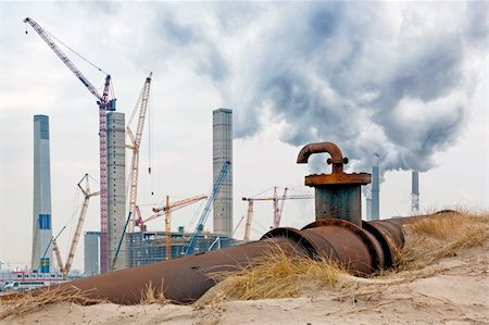 sand dunes large - An old oil pipe with valve and fosset being replaced by a new powerplant, being constructed in the background. Next to it, the old, fuming chimneys of the current powerplant Stock Photo - Budget Royalty-Free & Subscription, Code: 400-04923846