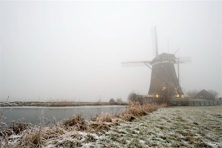 A typical Dutch windmill on a foggy winter morning with ice covered canals, and a frozen dyke Stock Photo - Budget Royalty-Free & Subscription, Code: 400-04923892