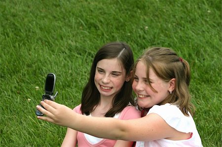 Girls Using a Cell Phone to take their picture Stock Photo - Budget Royalty-Free & Subscription, Code: 400-04934199