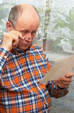 simsearch:400-04435288,k - Upset casual bald senior man with glasses looks at photo. Emotional portrait series. Photographie de stock - Aubaine LD & Abonnement, Code: 400-04934556