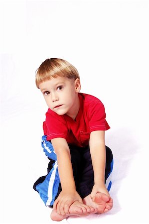 simsearch:400-08401650,k - A cute four year old boy wearing red and blue who is sitting and touching his toes. Foto de stock - Royalty-Free Super Valor e Assinatura, Número: 400-04937677