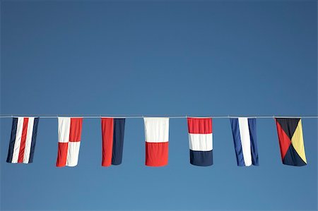 nautical flags strung along the line of a cruise ship Photographie de stock - Aubaine LD & Abonnement, Code: 400-04938335