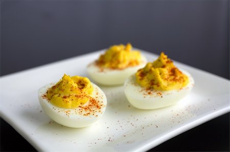 deviled egg - three deviled eggs with smoked paprika on a white plate Stock Photo - Budget Royalty-Free & Subscription, Code: 400-04938479