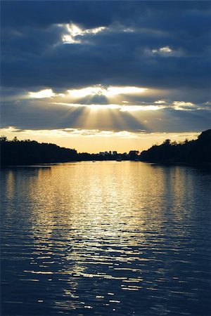 simsearch:400-05026123,k - Rays of sun shining through the clouds and sunset over water Photographie de stock - Aubaine LD & Abonnement, Code: 400-04938509