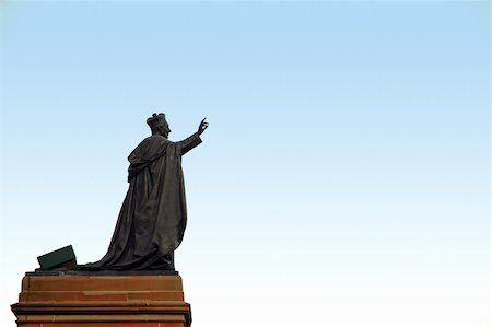 pape (religion) - dark grey pope sculpture with one hand lifted up, sculpture is on brown stand, light blue sky, Photographie de stock - Aubaine LD & Abonnement, Code: 400-04938638