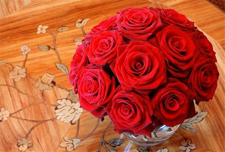 simsearch:400-04579308,k - A vase full of red roses in a clear glass vase on a wooden table. Photographie de stock - Aubaine LD & Abonnement, Code: 400-04938782