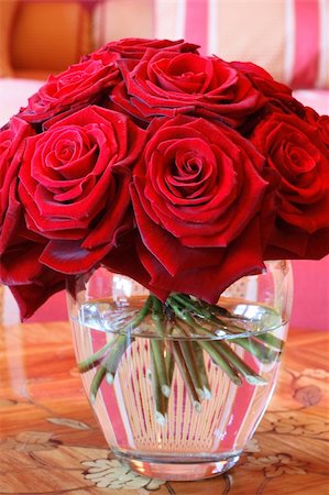 simsearch:400-04527694,k - A vase full of red roses in a clear glass vase on a wooden table. Foto de stock - Royalty-Free Super Valor e Assinatura, Número: 400-04938783
