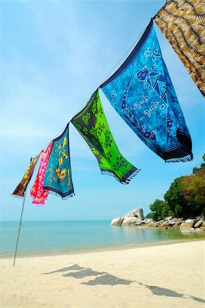 Batik is hanged at the beach. Batik is hand-dying clothes, is traditional handicraft in tropical country like Malaysia and Hawaii. Photographie de stock - Aubaine LD & Abonnement, Code: 400-04931873