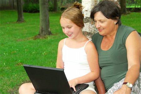 family with tablet in the park - Grandmother and granddaughter sitting outside with laptop computer Stock Photo - Budget Royalty-Free & Subscription, Code: 400-04931994