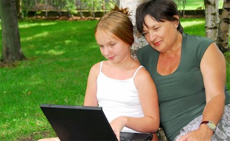 family with tablet in the park - Grandmother and granddaughter sitting outside with laptop computer Stock Photo - Budget Royalty-Free & Subscription, Code: 400-04932177
