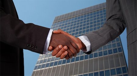 simsearch:400-03956950,k - This is an image of two business hands performing a handshake, with a corporate building in the background. Foto de stock - Royalty-Free Super Valor e Assinatura, Número: 400-04932219