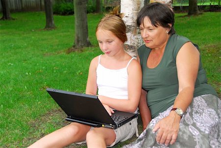 family with tablet in the park - Grandmother and granddaughter sitting outside with laptop computer Stock Photo - Budget Royalty-Free & Subscription, Code: 400-04932310