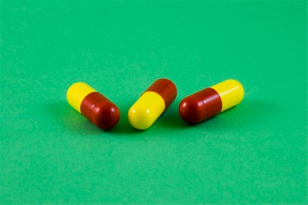 simsearch:400-05728490,k - Three red and yellow pills, could be anything from vitamins to illegal drugs but actually cold and flu tablets! Photographie de stock - Aubaine LD & Abonnement, Code: 400-04933205