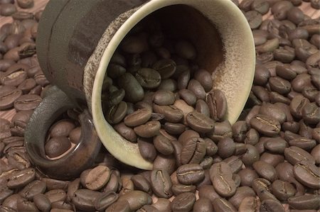 simsearch:400-04518865,k - Brown cup filled with coffee beans against wooden background Stock Photo - Budget Royalty-Free & Subscription, Code: 400-04933405