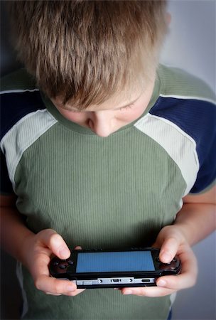 Boys hand playing portable video game Stock Photo - Budget Royalty-Free & Subscription, Code: 400-04933442