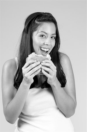 Smiling Female eats tasty hamburger Foto de stock - Super Valor sin royalties y Suscripción, Código: 400-04944603