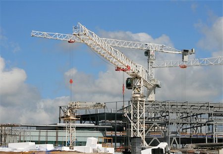 polystyrène - A construction site, with cranes, against a cloudy blue sky. Foto de stock - Super Valor sin royalties y Suscripción, Código: 400-04944679