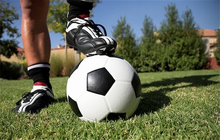Man standing with his foot/ soccerboot on the soccer ball in his back yard. Stock Photo - Budget Royalty-Free & Subscription, Code: 400-04944694