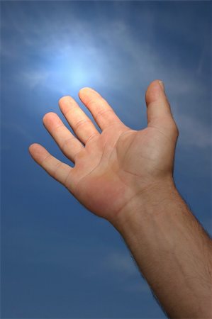 simsearch:400-04662543,k - Hand of a man reaching towards a blue sky with a light glow coming from his forefinger. Stock Photo - Budget Royalty-Free & Subscription, Code: 400-04944941